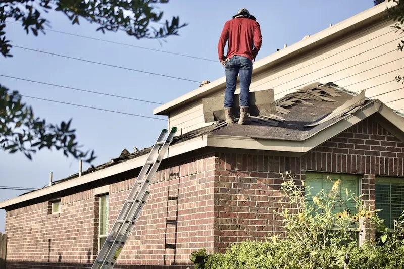Professional roofer working on a residential roof in Sands Point